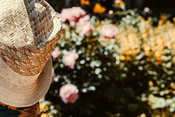 Men's braided summer hat. Blurred background of flowers.