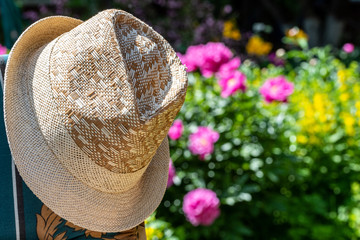 Men's braided summer hat. Blurred background of flowers.