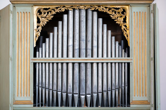 Old, silver organ pipes in a church used for playing sacred music. Many air pipes, sound tubes in the cathedral
