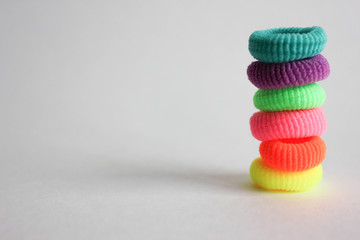  children's multicolor malteta hair ties, a pyramid of scrunchies for hair on a white background