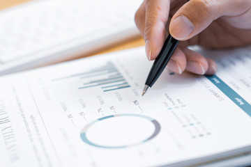 Close-up of hands Businessman reading and writing with pen signing contract over document for Completing Application Form at work in office.
