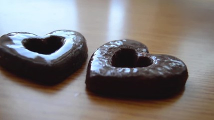 two heart shaped biscuits on the wooden table