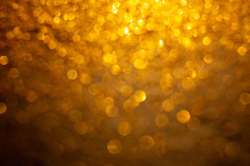 Gold glitter background with bokeh defocused orange lights