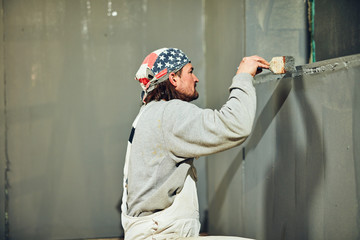 Painter painting walls with a paint brush.