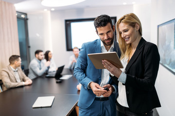 Businesspeople discussing while using digital tablet in office