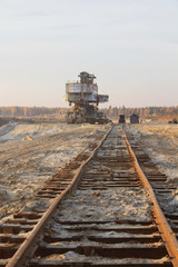 Rusty railroad tie. Giant stacker. Bucket chain excavator in a sand quarry. Bulk material handling