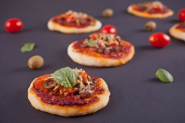 Homemade mini pizza on the black background.