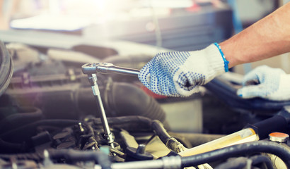 car service, repair, maintenance and people concept - auto mechanic man with wrench and lamp working at workshop