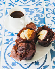 Cup of coffee and muffins on kitchen table.