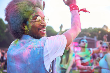 African man in holi colors dancing during music festival
