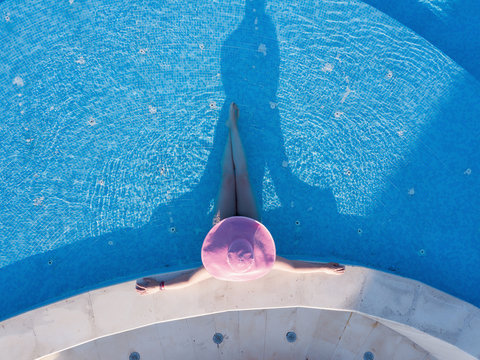 Young woman sunbathing in a swimming pool