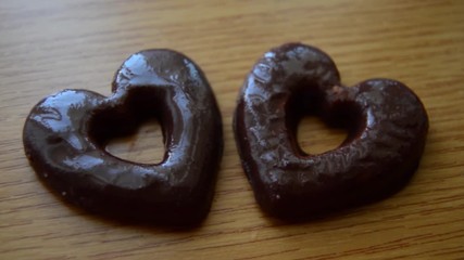 two heart shaped biscuits on the wooden table