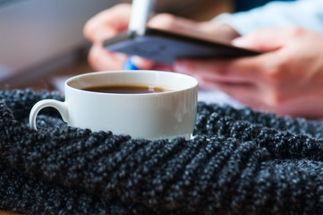 Cup of americano and scarf on windowsill.