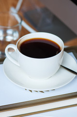 Cup of americano and books. Close up.