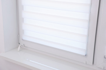 White roller blind on a metal plastic window