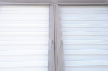 White roller blind on a metal plastic window