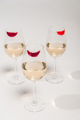 lipstick prints on champagne glasses with alcohol on white