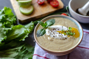 Healthy zucchini cream soup served with poached egg and greens. Proper nutrition food