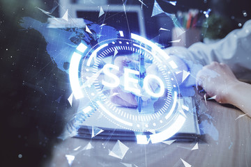 Multi exposure of woman's hands making notes with SEO icon. Concept of Search engine optimization