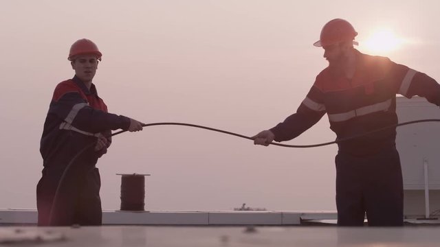 Mans Workers unwinds internet cable on the roof
