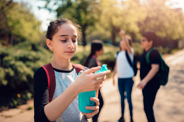 Schoolgirl drinking water at schoolyard