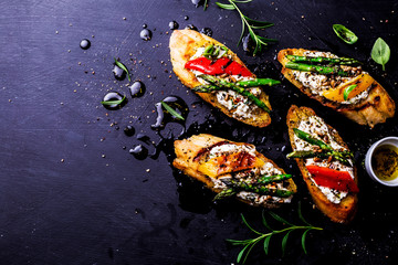 Toasts (sandwiches) with cheese, pepper and asparagus on black