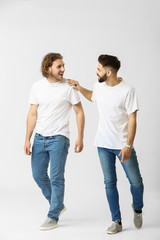 Stylish young men in jeans on white background