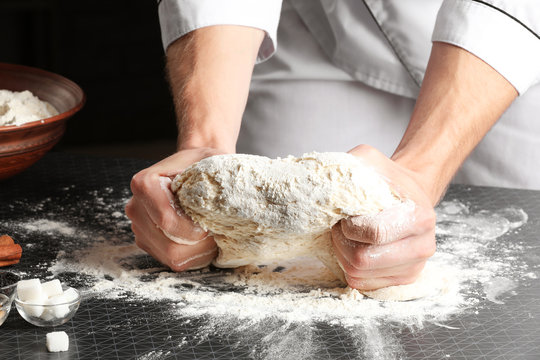 Man kneading dough in kitchen, closeup
