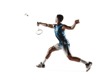 Fototapeta na wymiar Little boy playing badminton isolated on white studio background. Young male model in sportwear and sneakers with the racket in action, motion in game. Concept of sport, movement, healthy lifestyle.