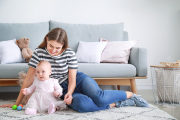 Fototapeta premium Happy mother with cute little baby at home