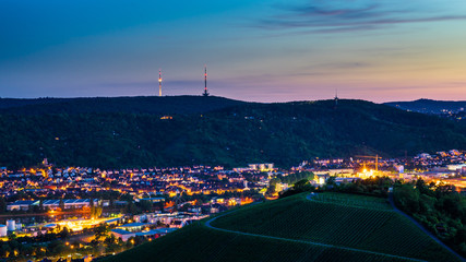 Germany, Illuminated television tower building on top of green mountain behind city lights of stuttgart houses in neckar valley