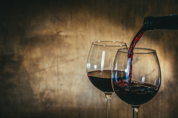 Red wine in glasses on rustic background, copy space