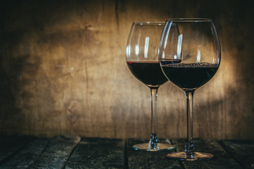 Red and white wine in glasses on rustic background, copy space