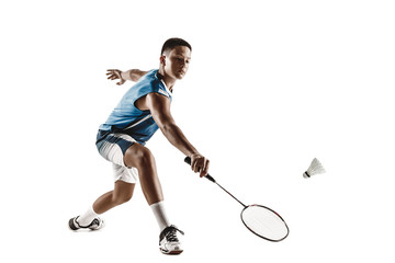 Little boy playing badminton isolated on white studio background. Young male model in sportwear and sneakers with the racket in action, motion in game. Concept of sport, movement, healthy lifestyle.