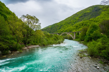 Fototapeta na wymiar Montenegro, Green forest area covering high mountains connected by bridge surrounding turquoise waters of moraca river in moraca canyon