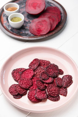 Plate with tasty beet chips on table