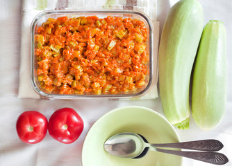 Squash stew with carrot and tomatoes in a square glass dish