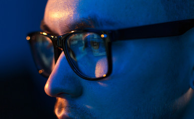 vision, hacking and technology concept - close up of hacker eyes in glasses looking at computer...