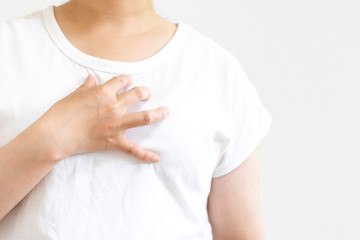 自分の胸を押さえて苦しむ女性