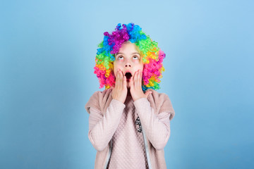 What a wonderful surprise. Surprised little girl wearing clown wig hair. Cute small girl opened mouth with big surprise. Adorable little child with surprise face. Looking with surprise