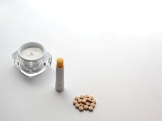 Set of items relieving side effects of isetretinoin treatment: moistuiser, lip balm and milk thistle.	