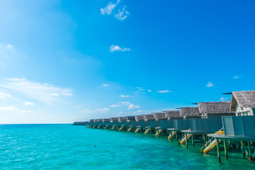 Fototapeta na wymiar Water villas over calm sea in tropical Maldives island .