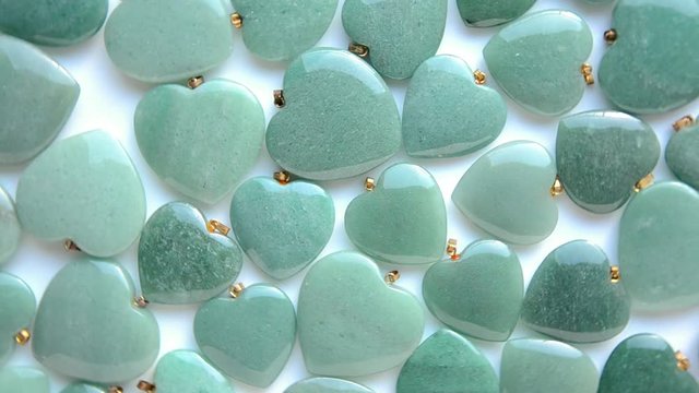 Semi-precious stone hearts of green aventurine are rotating in a clockwise direction top view