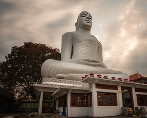 kandy sculpture giant buddha over the hill of the town with dramatic cloudy sky meditation concept