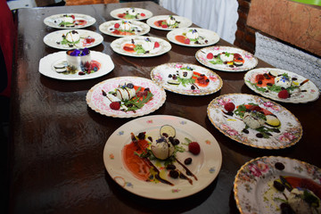 Colorful and healthy salads with vegetables and fruits on plates in a vintage restaurant