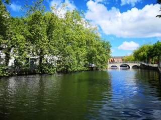 Walk on the canals and bridges of Bruges by a sunny summer day