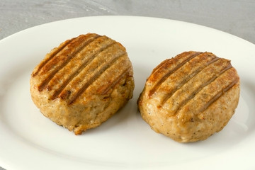 Two tasty juicy cutlets on a white plate