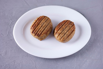 Two tasty juicy cutlets on a white plate