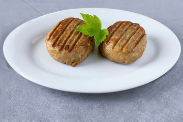 Two tasty juicy cutlets on a white plate