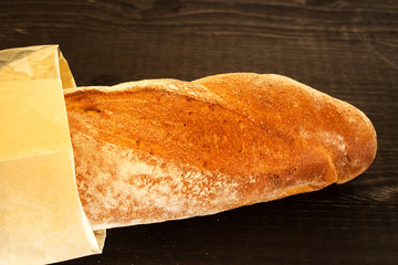 French baguette bread. Fresh baguette on a dark wooden background. Space for text.